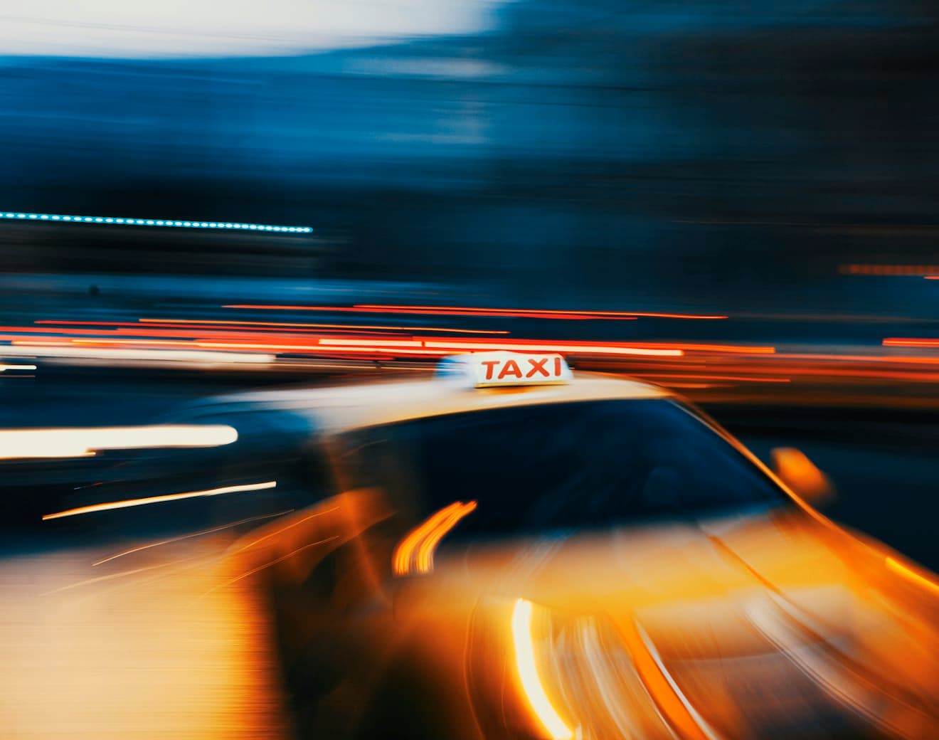 A taxi moving through a city at night