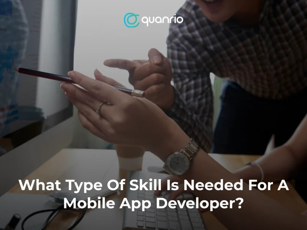 Two people discussing mobile app development skills, with one person pointing at a screen and the other holding a pencil."